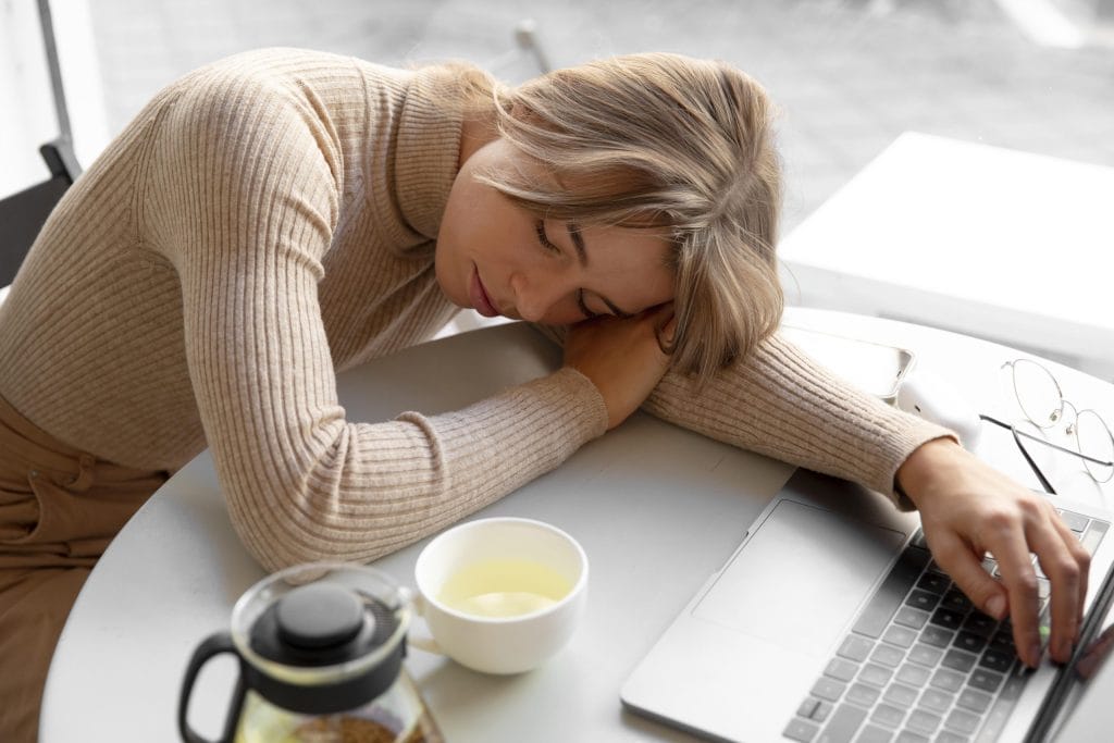 Personne endormie faisant la sieste devant son ordinateur
