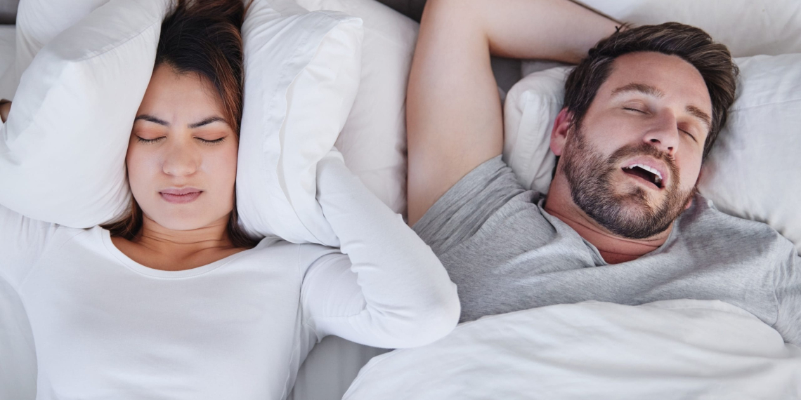 Homme ronflant dans le lit à cote de sa femme