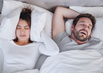 Homme ronflant dans le lit à cote de sa femme